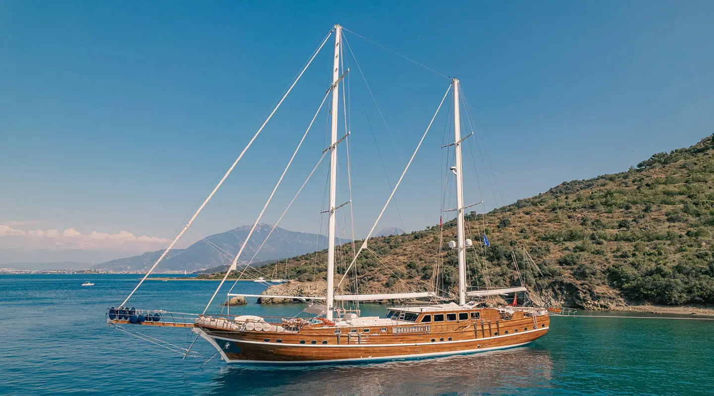Lycian Queen luxury gulet anchored at sunset with sails lowered and calm blue sea