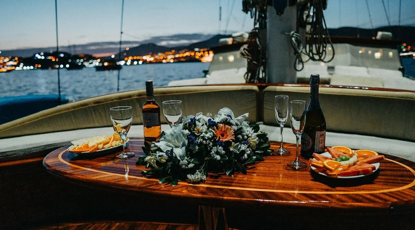 Wicked Felina yacht bow with bouquet on polished teak deck at sunset