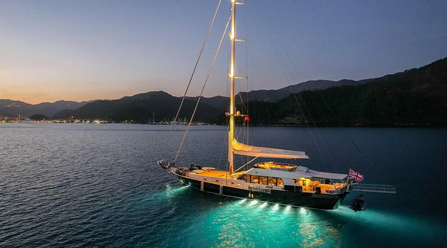 Good Life yacht anchored near islands at sunset with calm turquoise water