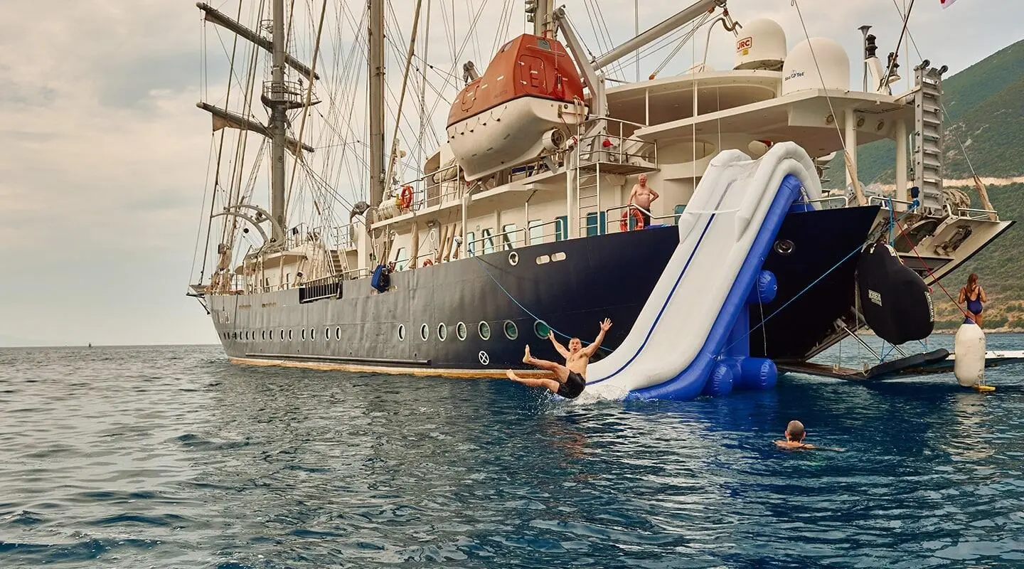 Gulet cruising on waves with a water slide touching the water