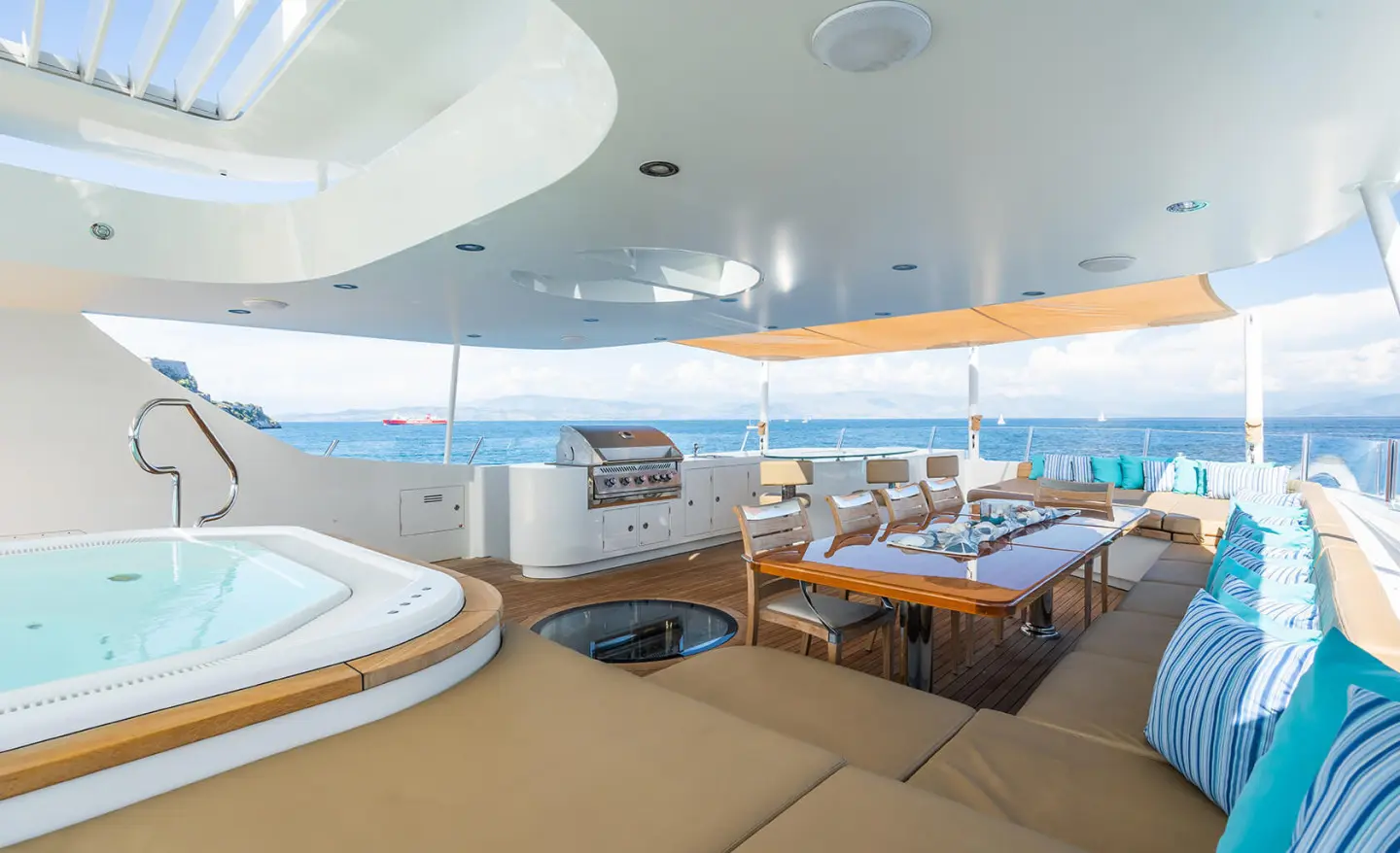 Serenity yacht sun deck with cushioned seating and a table