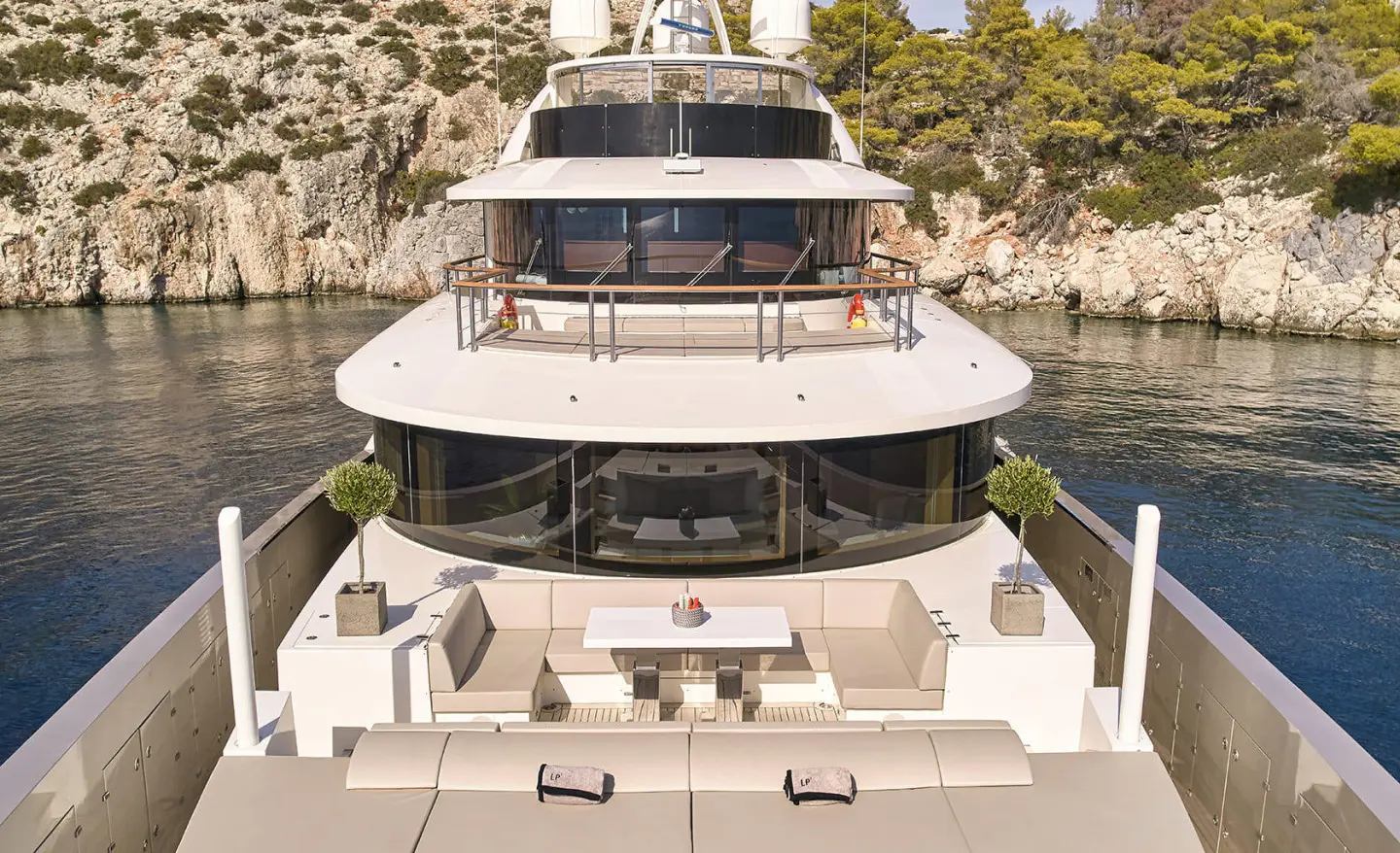 Bow deck of motoryat La Pellegrina 1, calm seas, teak railings, sun loungers