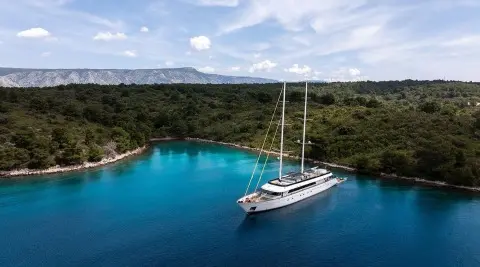 Luxury sailing yacht Anima Maris anchored in turquoise bay with clear blue water