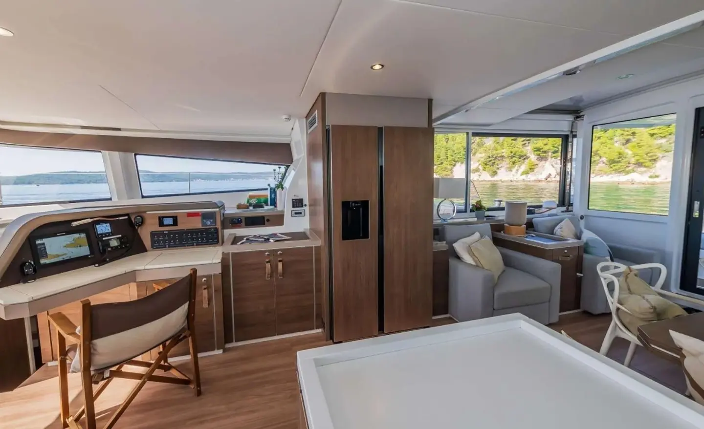 Interior of Ocean Lounge yacht: wood tones, seating, large window, deck visible