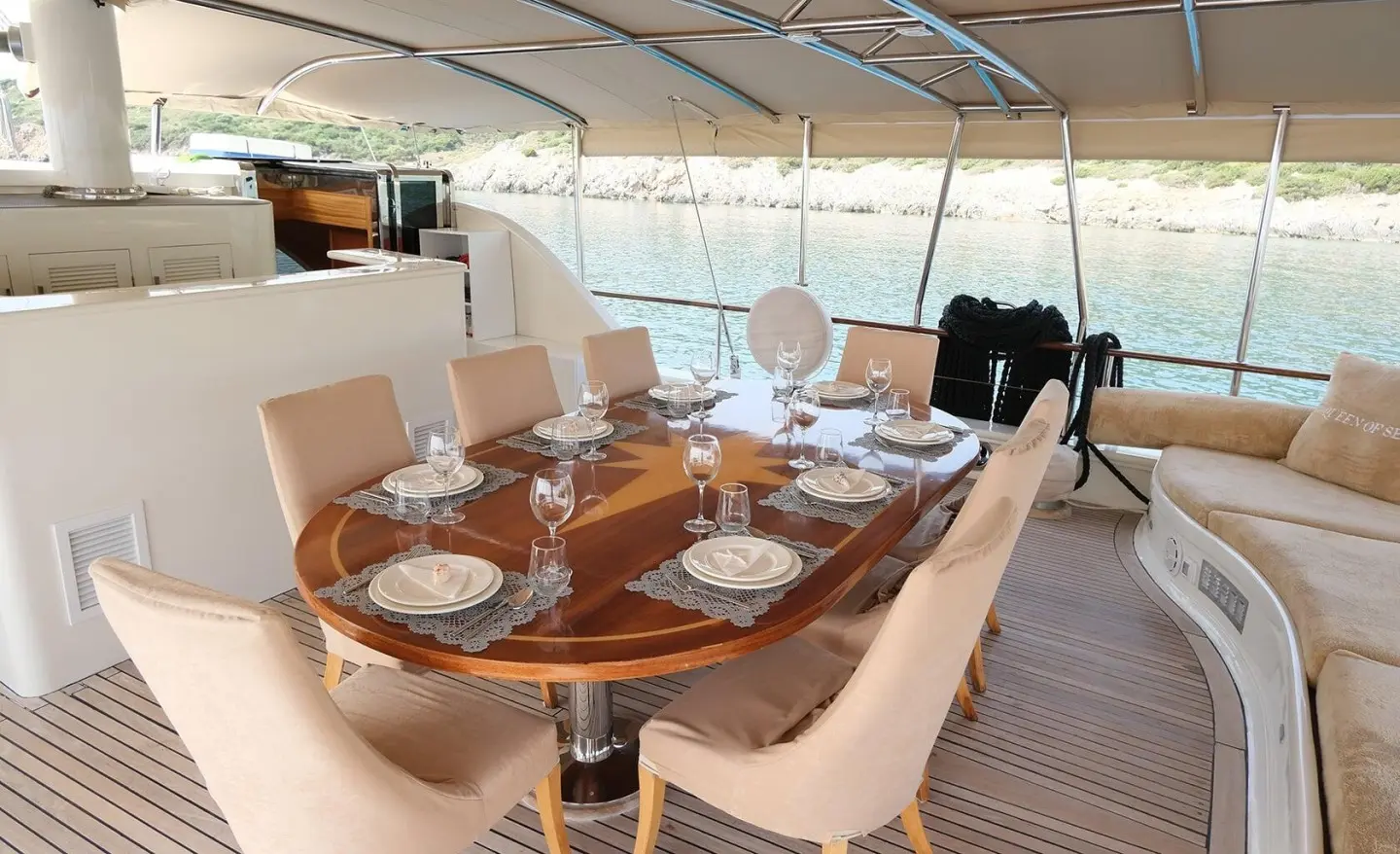 Queen Of Sea luxury gulet sailing at sunset with dining table set on deck