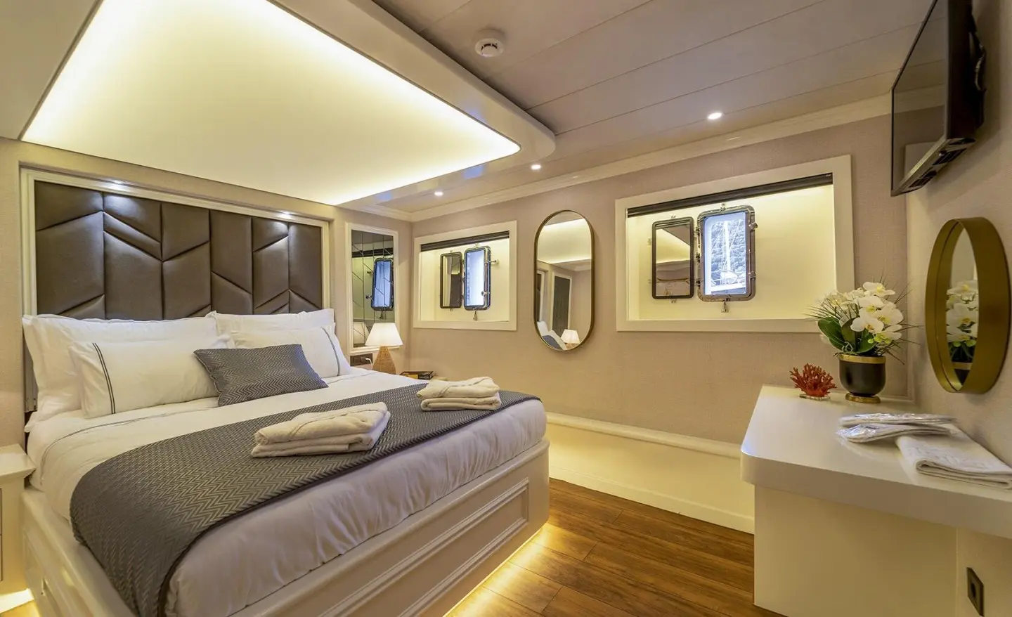Queen Of Makri luxury gulet interior with beds and warm lighting at sunset