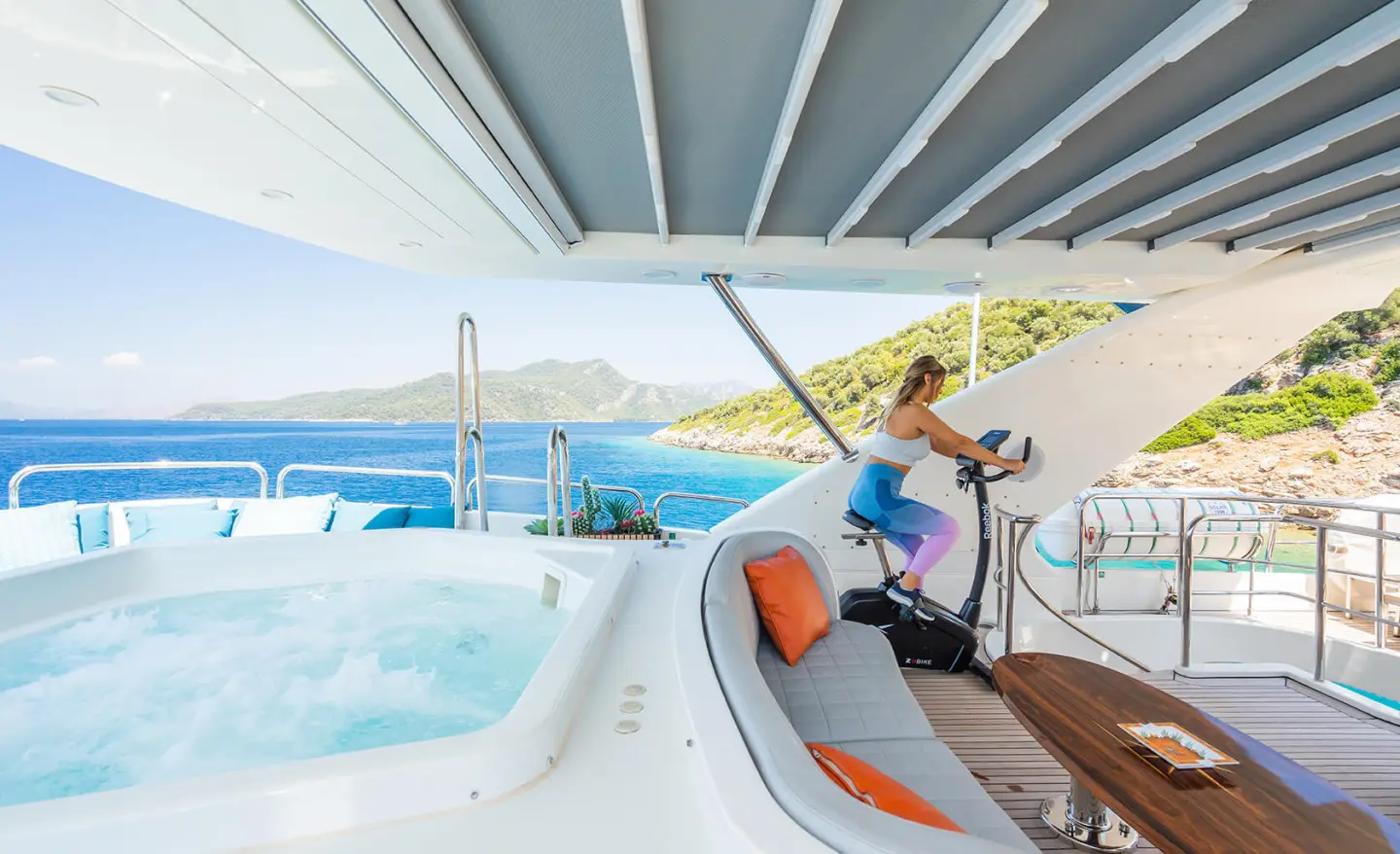 Yacht Amadea exterior deck with seating and railing by pool on sunny day