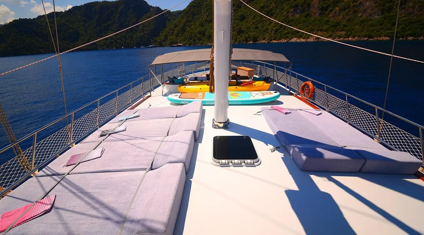 Maya yacht deck at sunset, sunlit white surface, blue sea in background