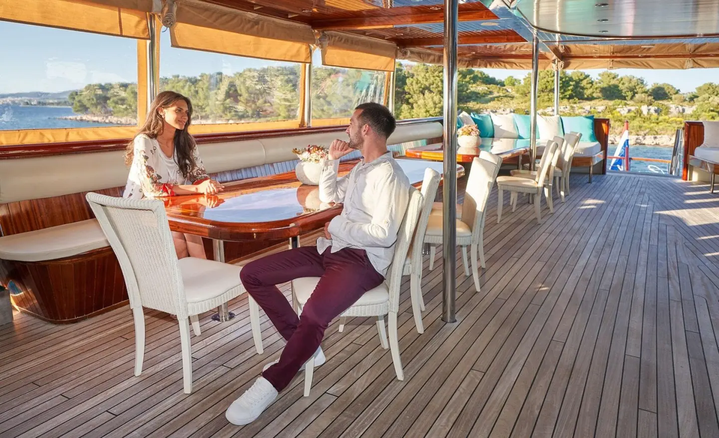 Casablanca yacht deck with guests seated at a table under a shaded canopy