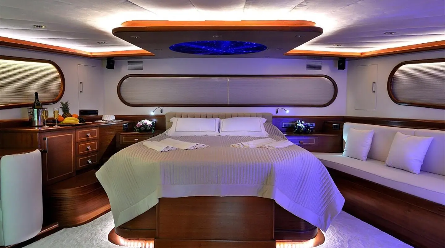 Dolce Mare gulet master cabin interior with wooden floor and bed