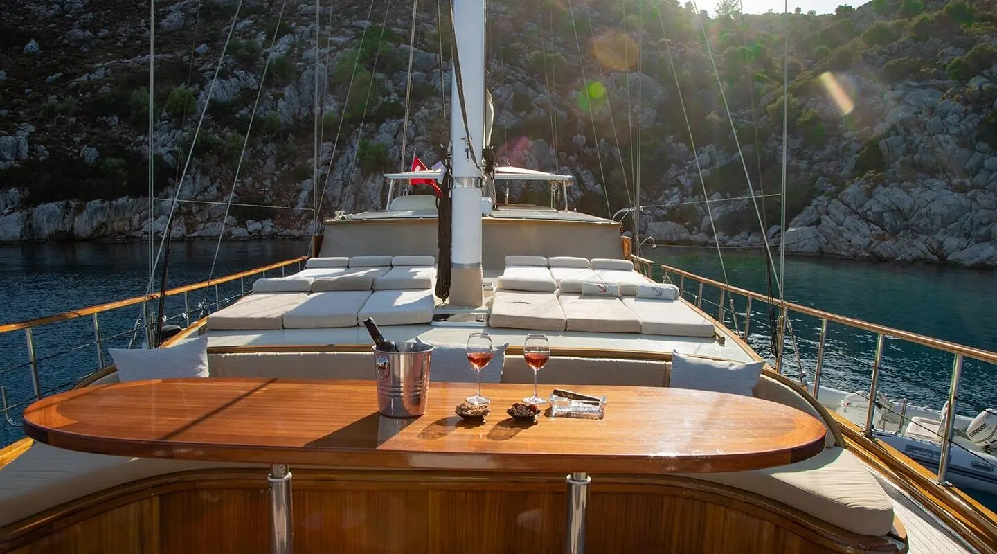Derin Deniz yacht deck at sunset with wooden benches and calm water view