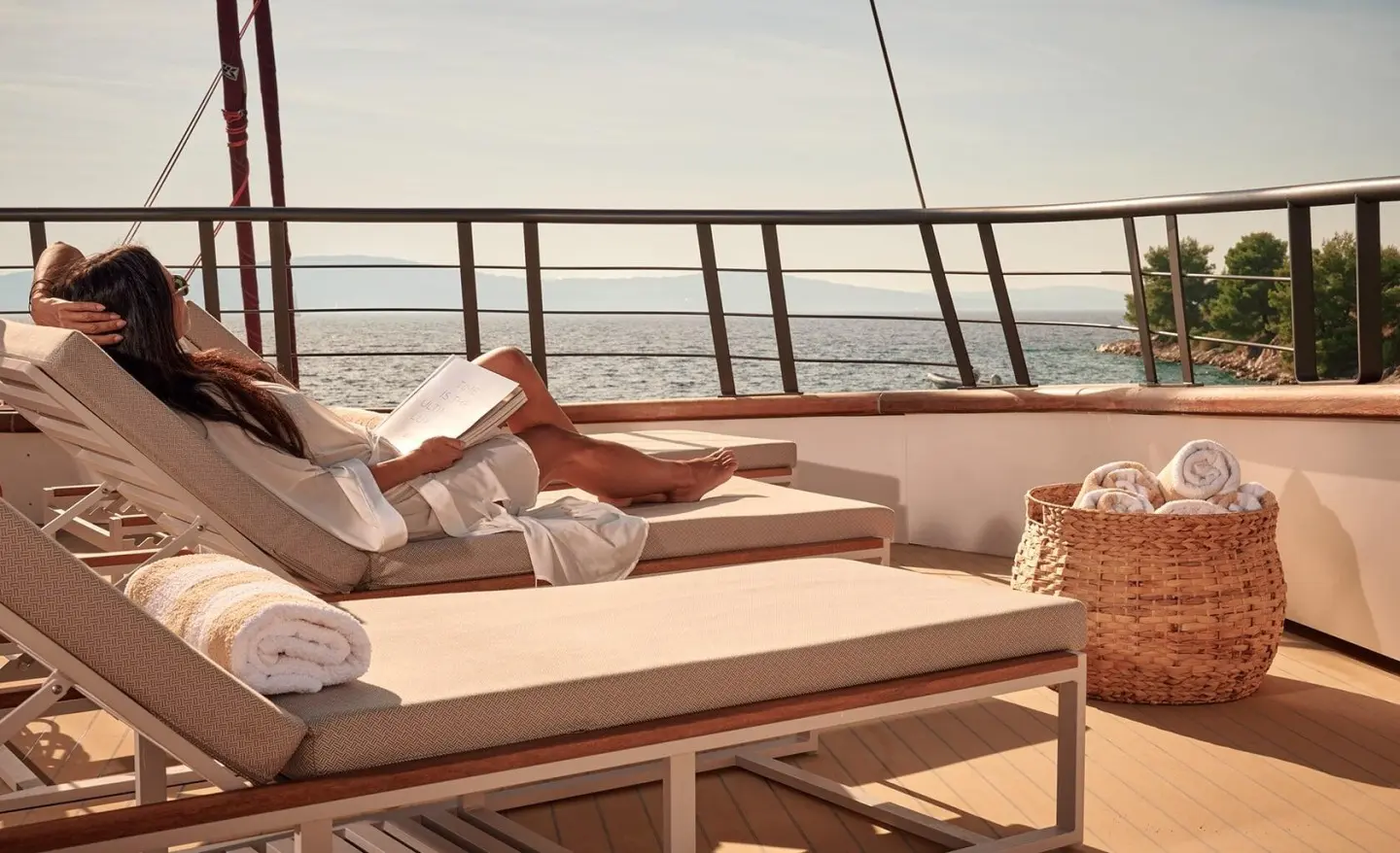 Anetta yacht deck seating area with cushions and railing at sunset