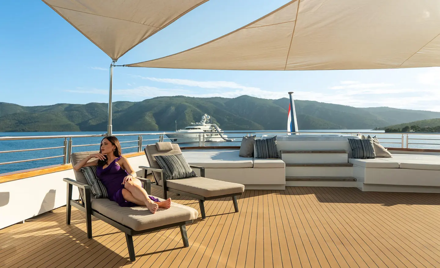 Cristal yacht sun deck with loungers under shade sails overlooking blue sea