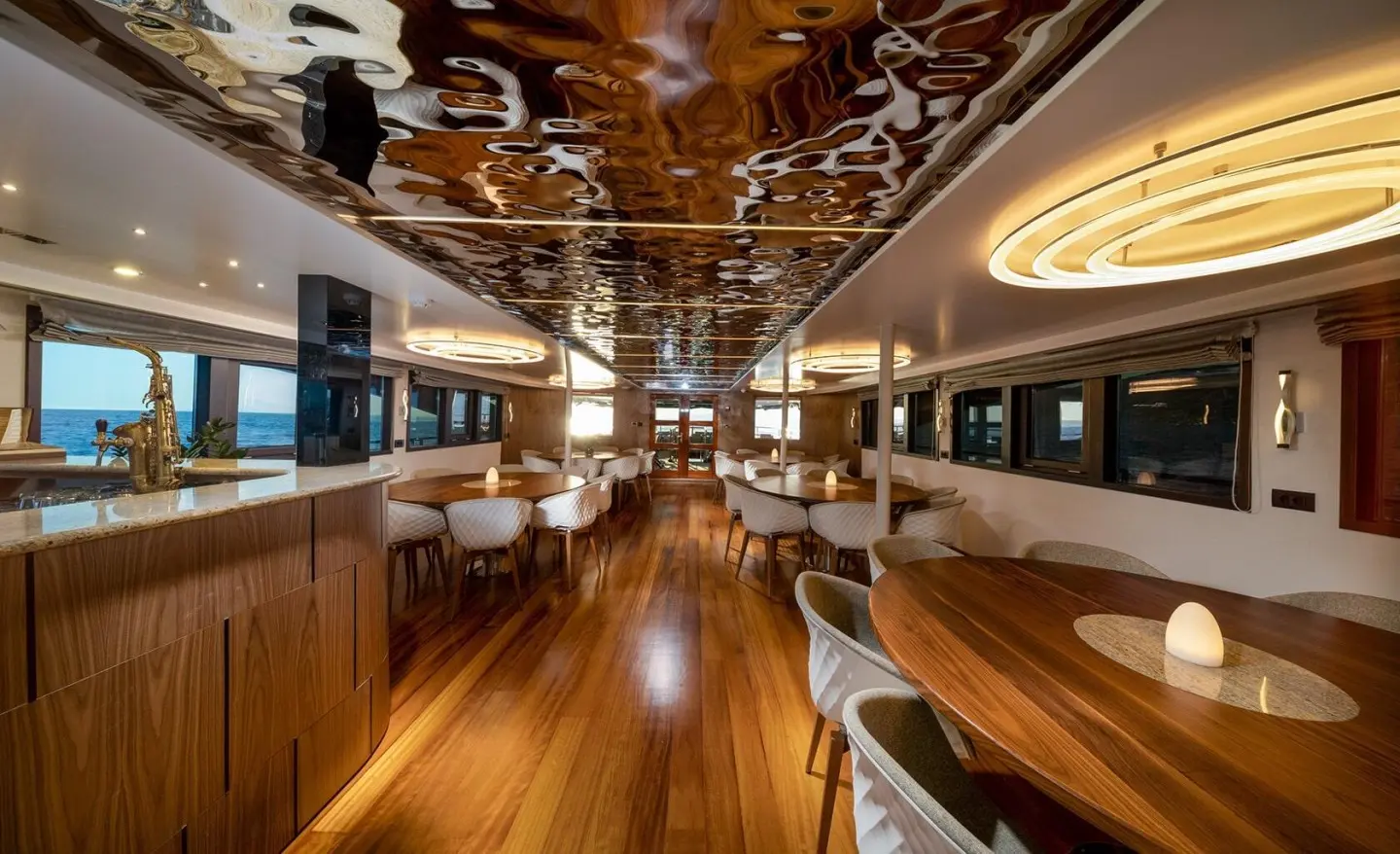Olimp yacht salon deck interior with wood floor, seating, and glossy fixtures