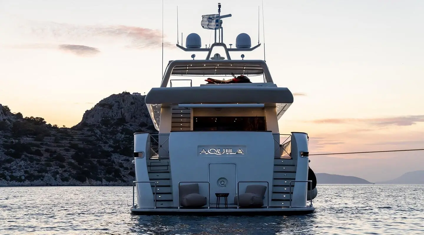 Aquila motor yacht seen from rear, white hulls, multiple decks, calm sea