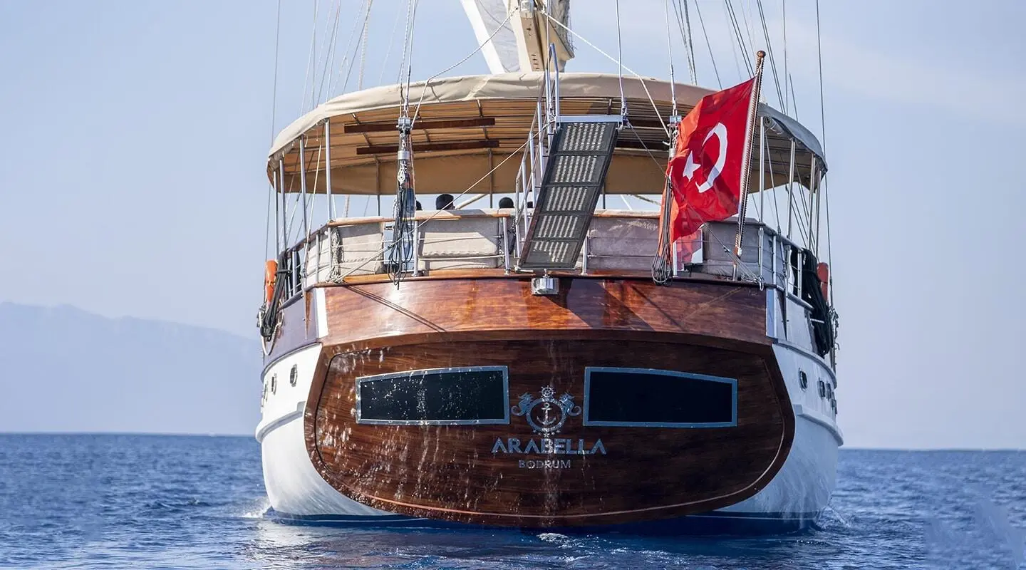 Arabella yacht at sunset with Turkish flag on stern and wooden deck