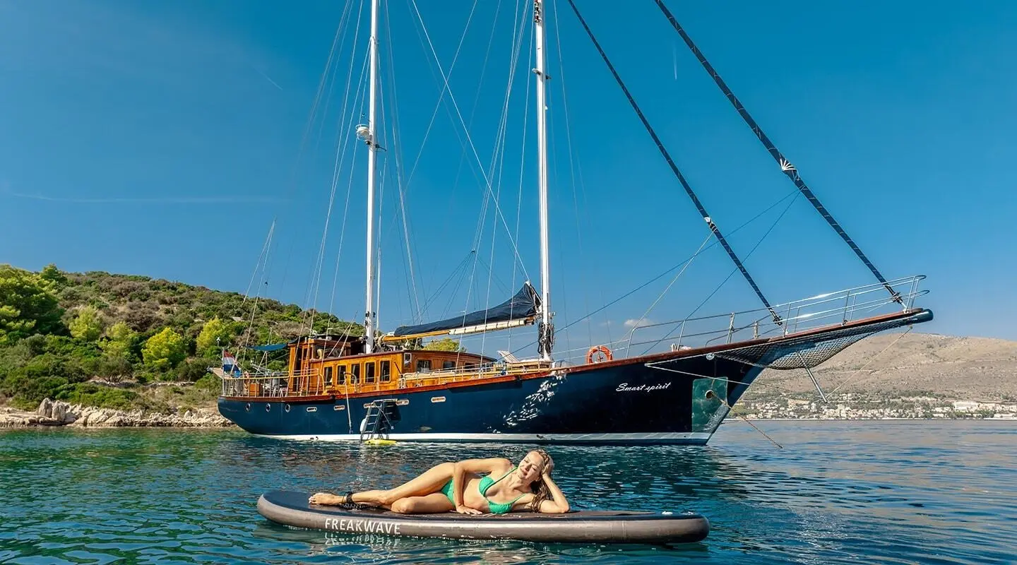 Smart Spirit yacht anchored with a small inflatable boat nearby at sunset