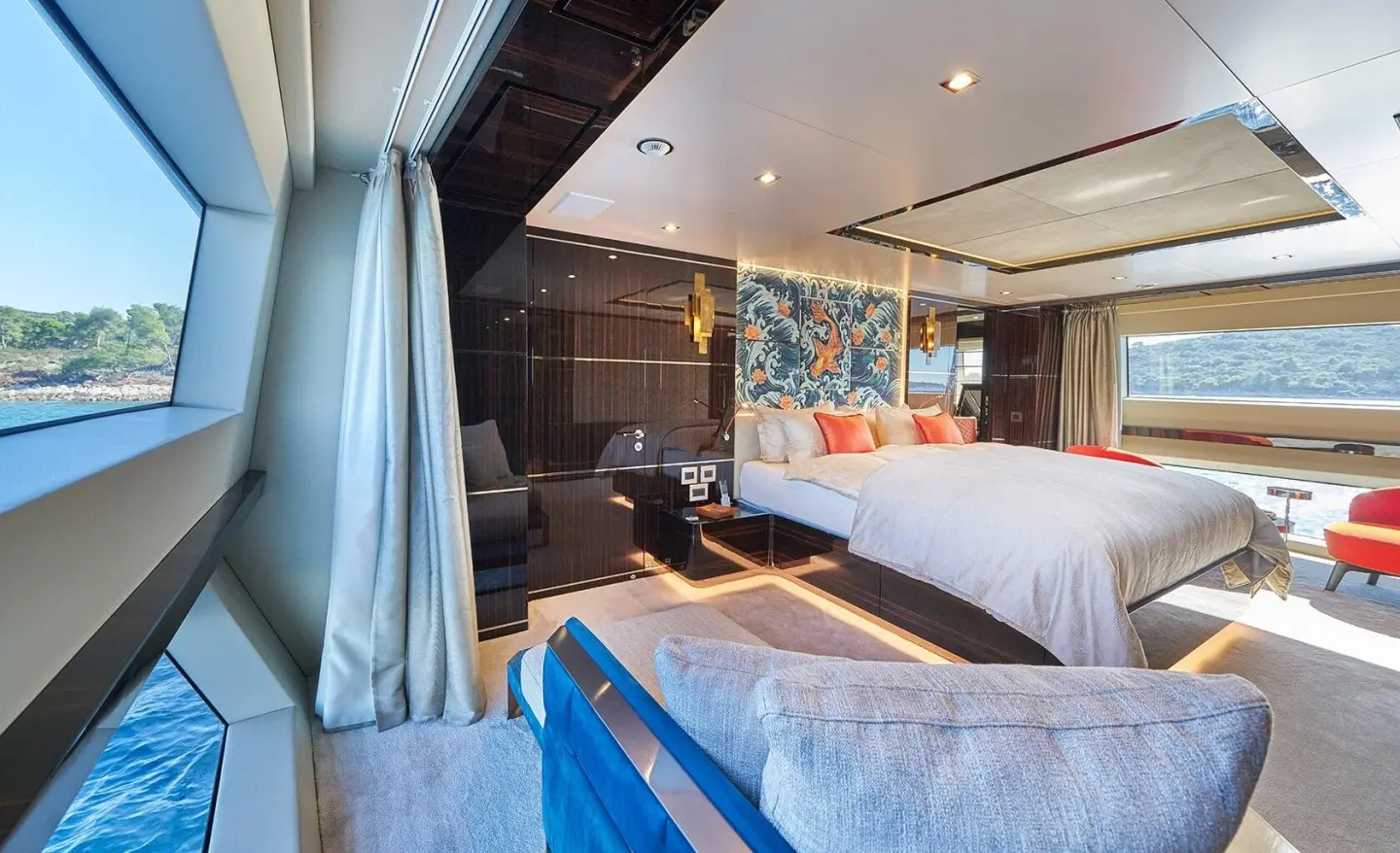 Cozy yacht cabin with a large bed, blue and gray decor, sunset light