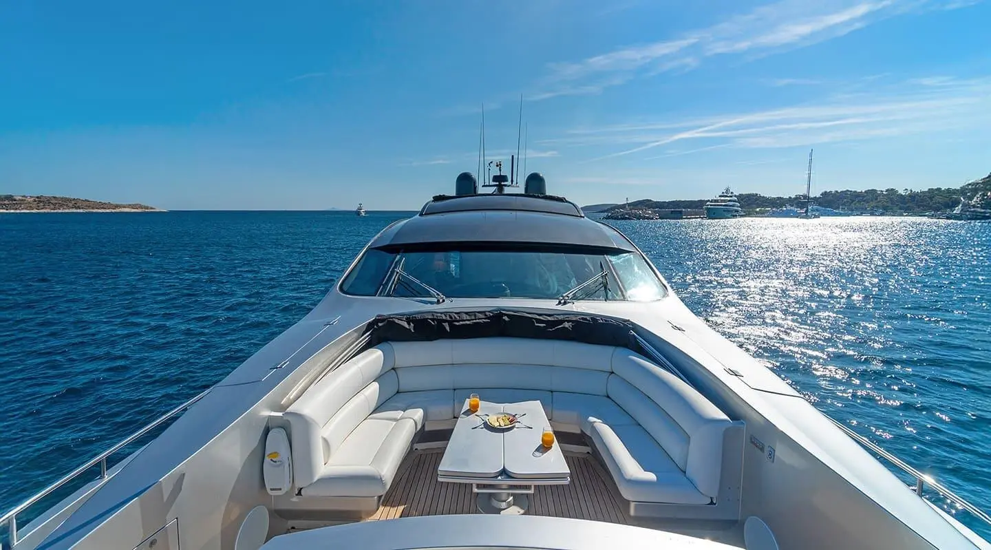 Front deck view of a luxury yacht with seating and a table on bow