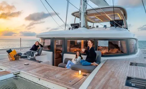Daiquiri luxury yacht deck with people lounging on seating and sunset views