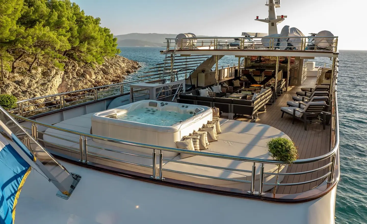 Yacht Freedom sun deck with hot tub, lounge chairs, and water views