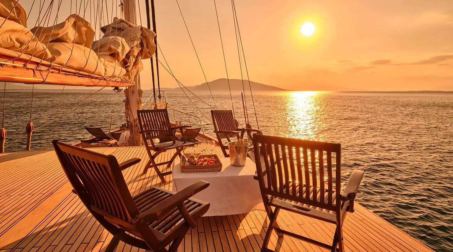 Myra yacht on calm sea at sunset, seating area with chairs and sun loungers on deck