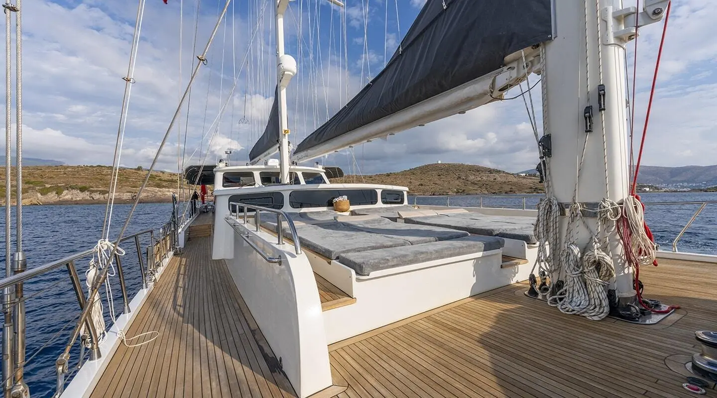 Lucky You yacht deck with sun loungers and rigging on a calm blue sea