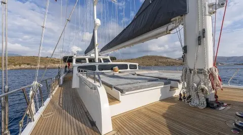 Lucky You yacht deck with sun loungers and rigging on a calm blue sea