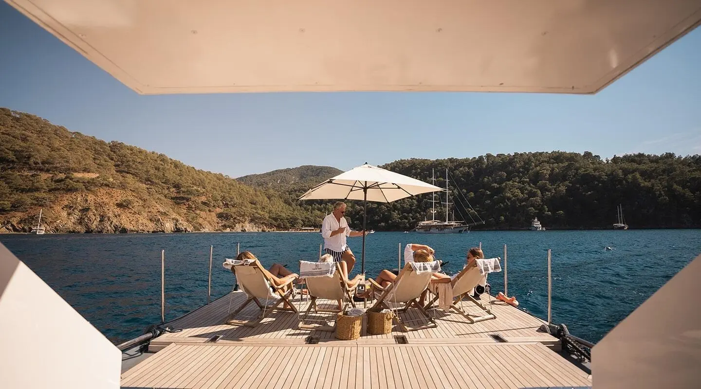 North Wind yacht dockside with sun loungers and umbrella on deck swim platform