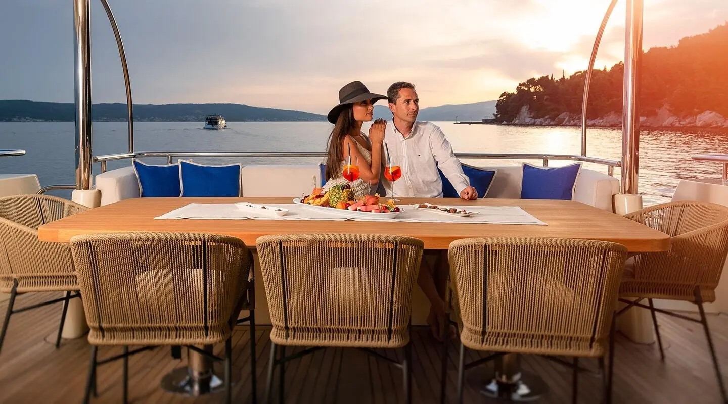 Grace yacht dining at sunset with couple seated at a table on deck
