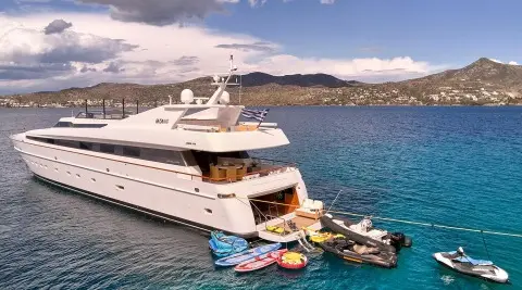Luxurious white Mobius yacht anchored near rocky coastline at sunset