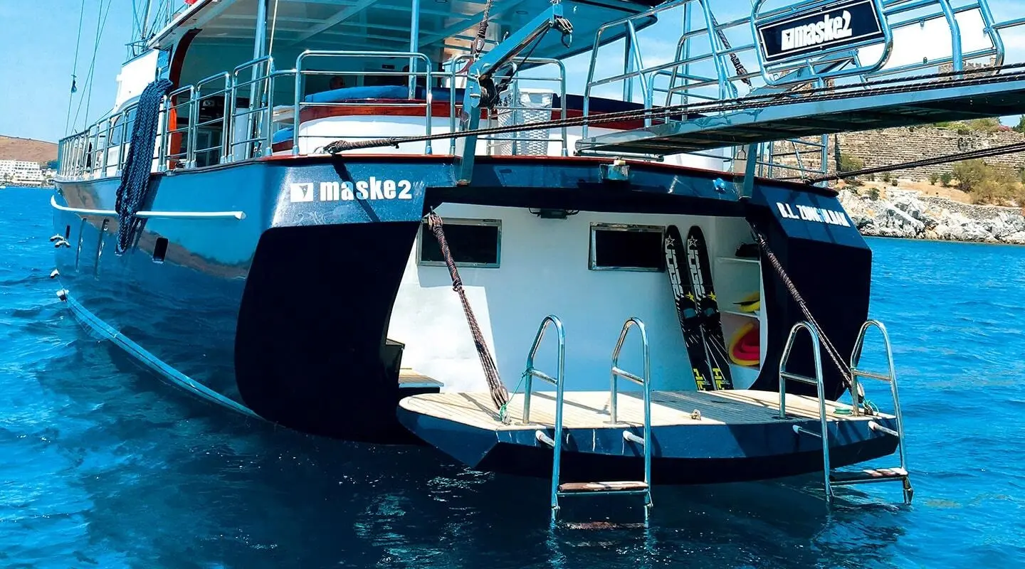 Maske 2 yacht at sunset with blue water and deck stairs visible