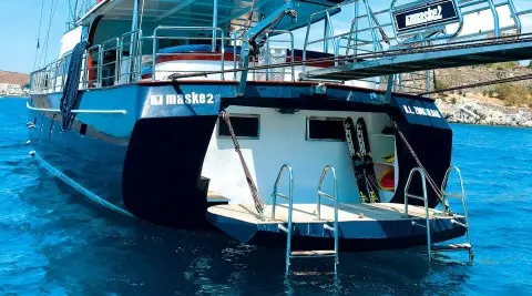 Maske 2 yacht at sunset with blue water and deck stairs visible