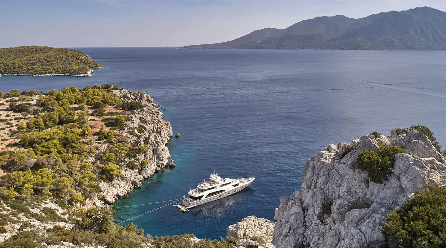 La Pellegrina 1 yacht docked in blue bay between rocky cliffs and clear water