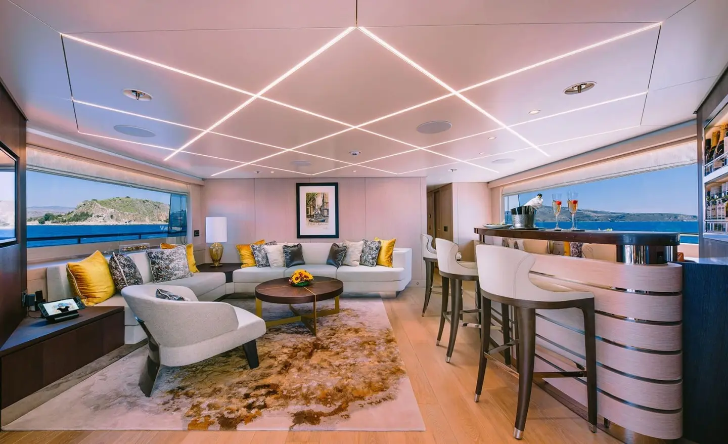 Cozy yacht interior seating area with sofa, chairs, and coffee table under warm lighting