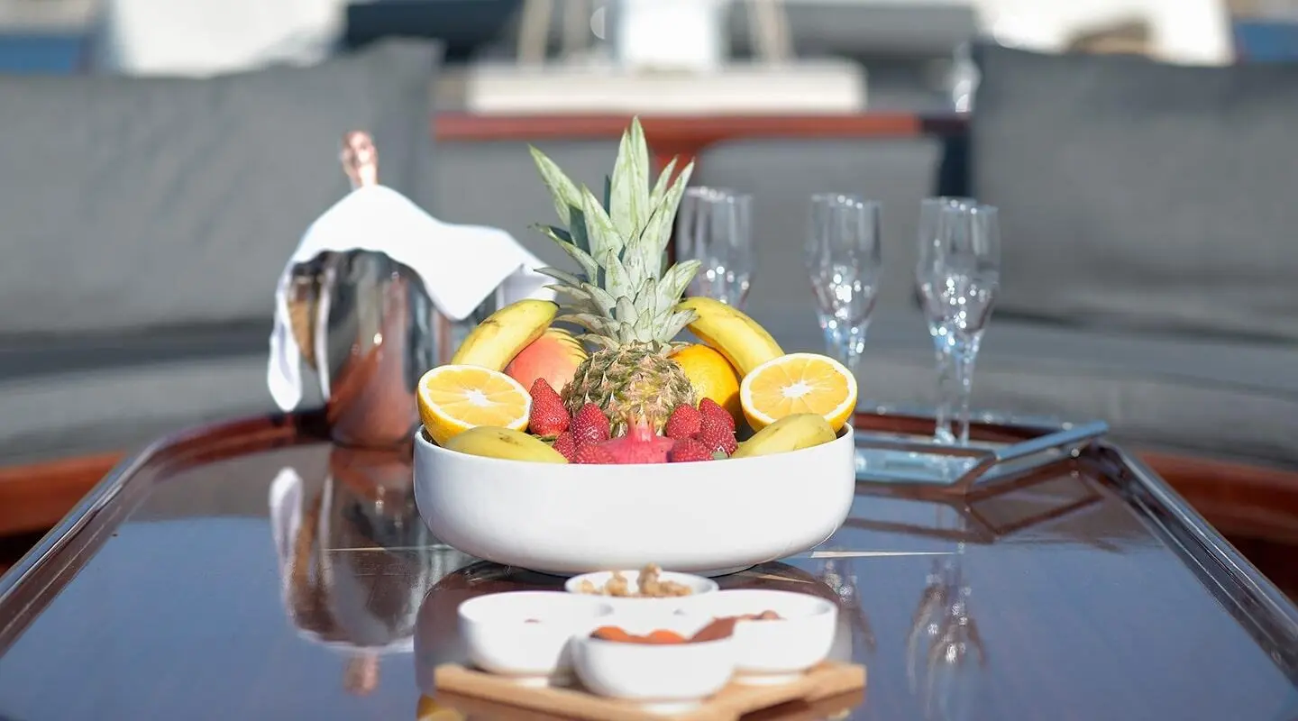 Cobra King yacht scene with a fruit-topped pedestal and beverages on deck