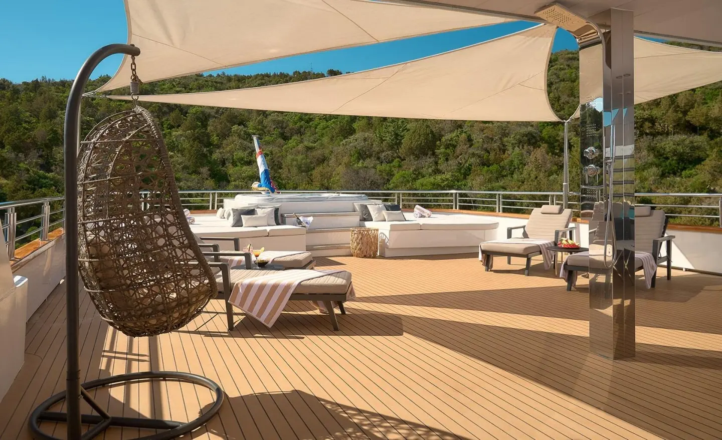 Cristal yacht deck with sun loungers, shade sail, and seating area on light wooden deck