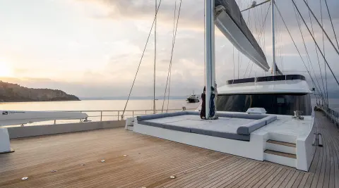 Yacht De Love docked at sunset with sails and wooden deck