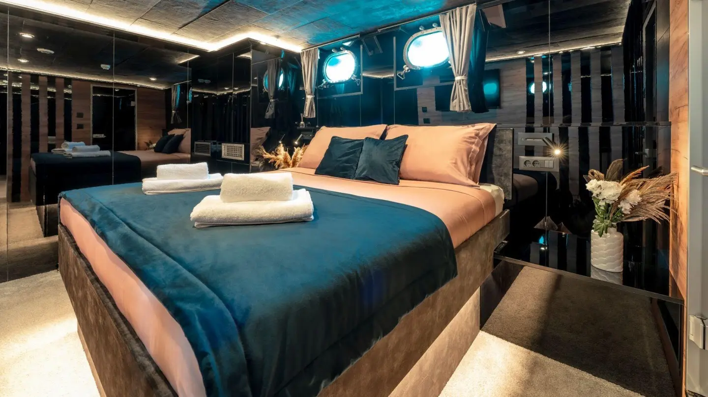 Yacht Santa Clara interior with double cabin, bed, pillows, and warm lighting