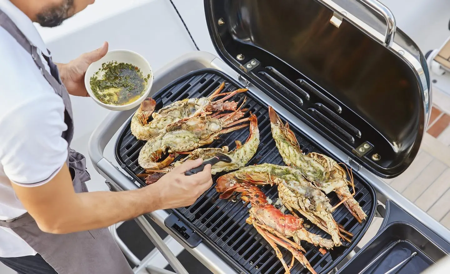 Chef grilling seafood on the Daiquiri yacht with shrimp and seafood on the grill