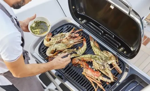Chef grilling seafood on the Daiquiri yacht with shrimp and seafood on the grill