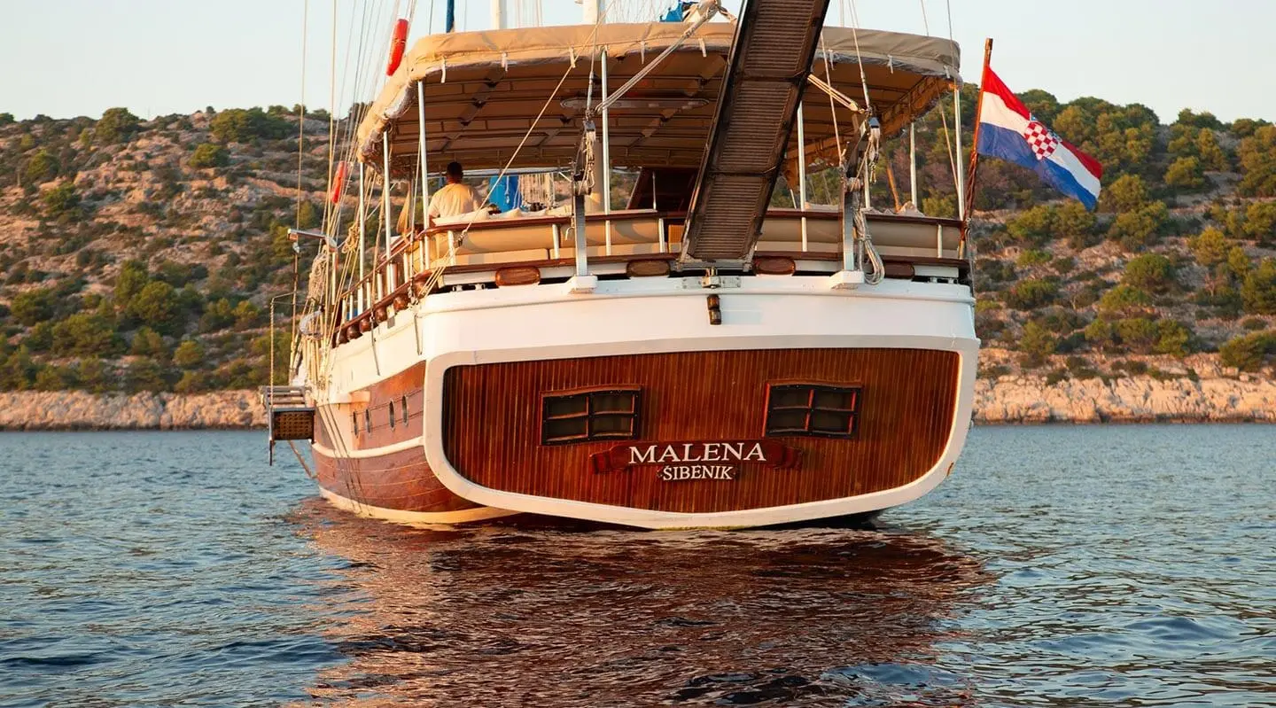 Yacht Malena at sunset with wooden hull and open stern deck