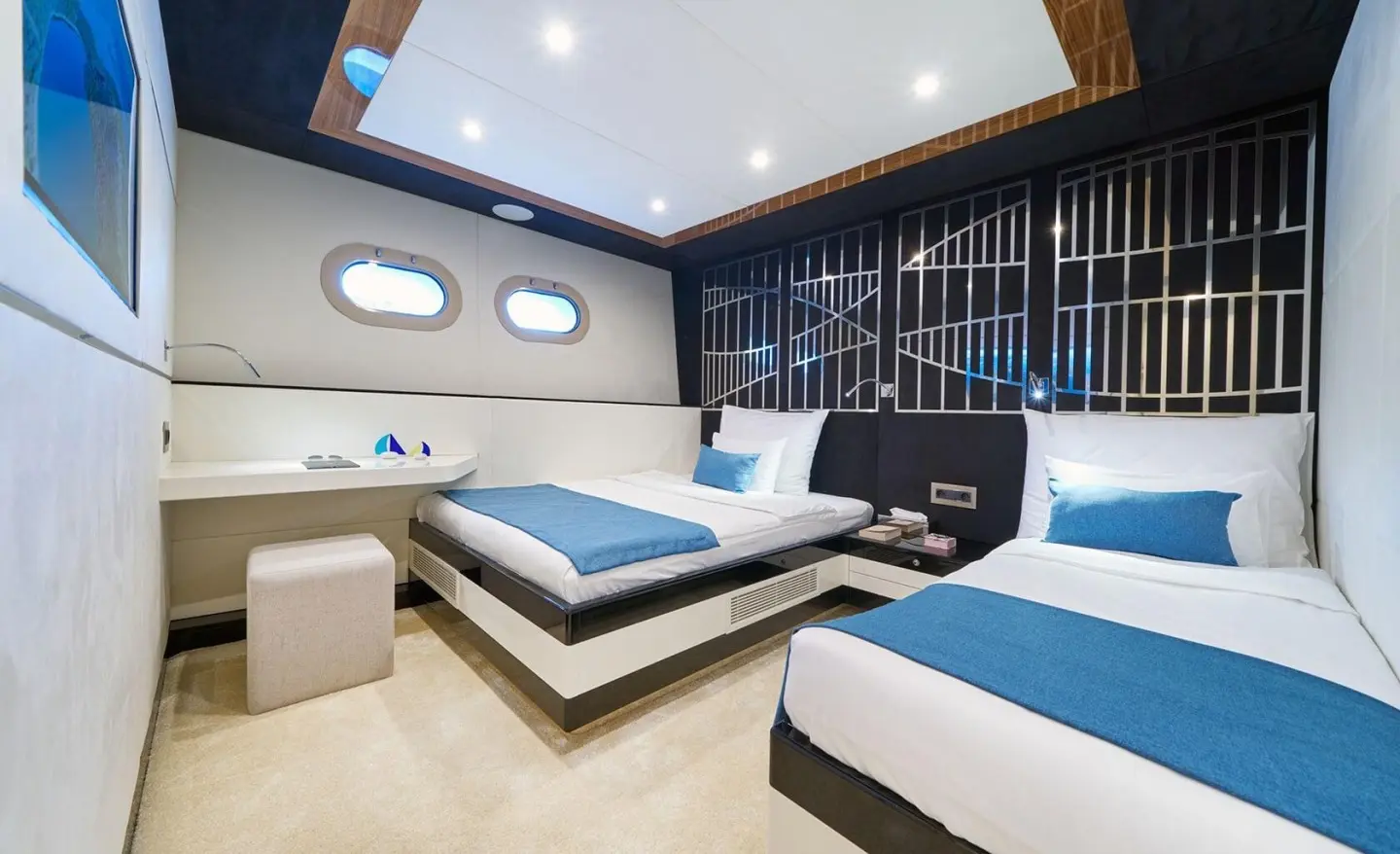 Interior of Acapella yacht showing two twin beds and blue accents