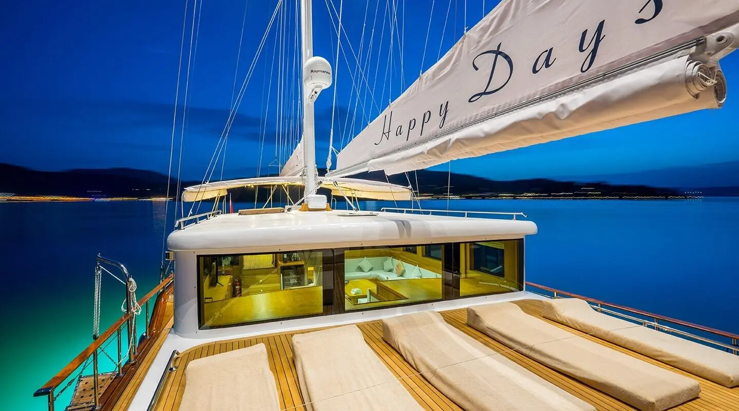 Happy Days 30m luxury sailing yacht at dusk with sun loungers on deck