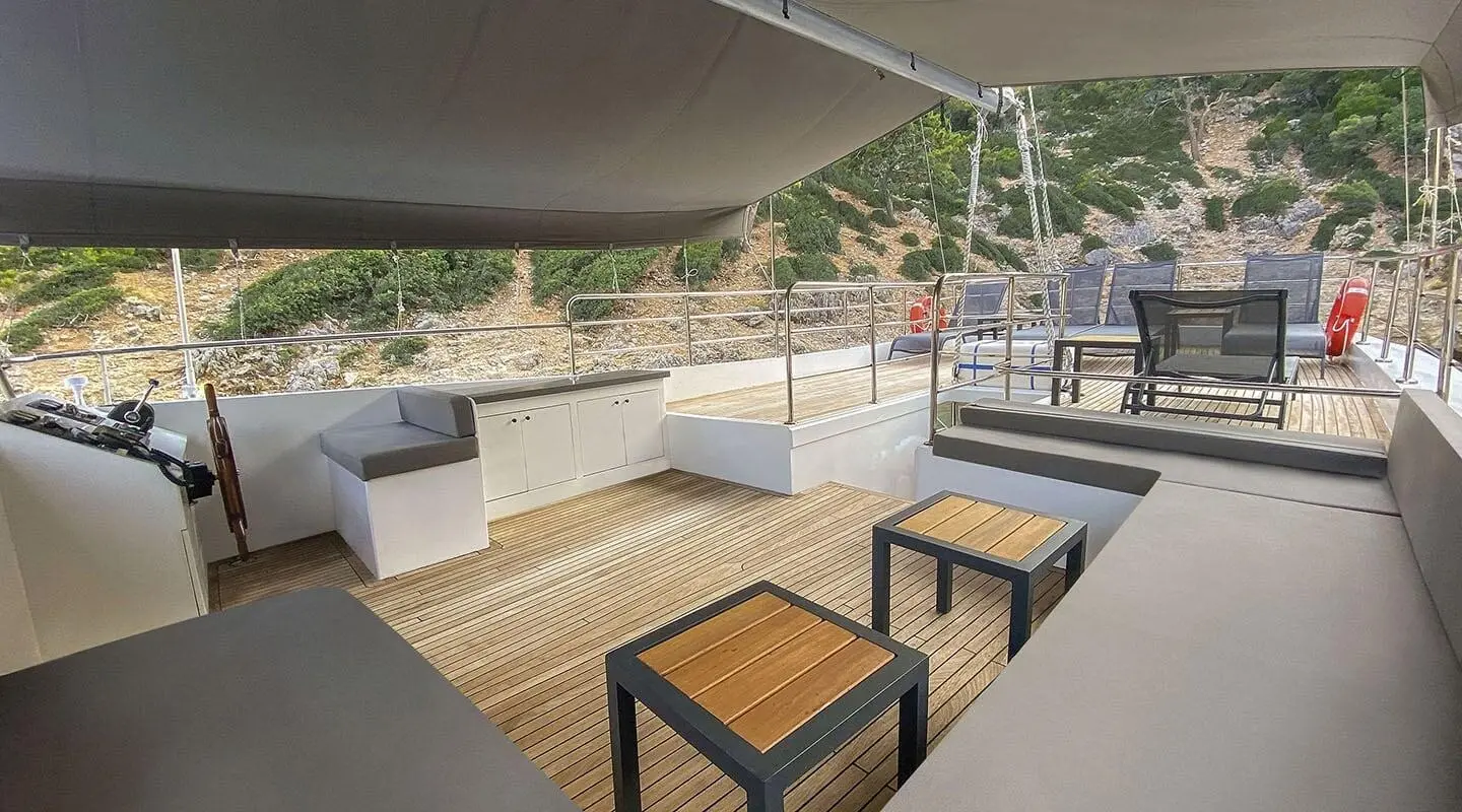Maske 5 yacht on calm sea with deck seating under shade at sunset