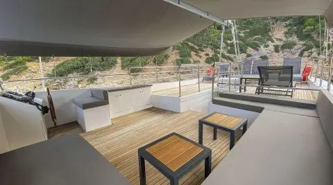 Maske 5 yacht on calm sea with deck seating under shade at sunset