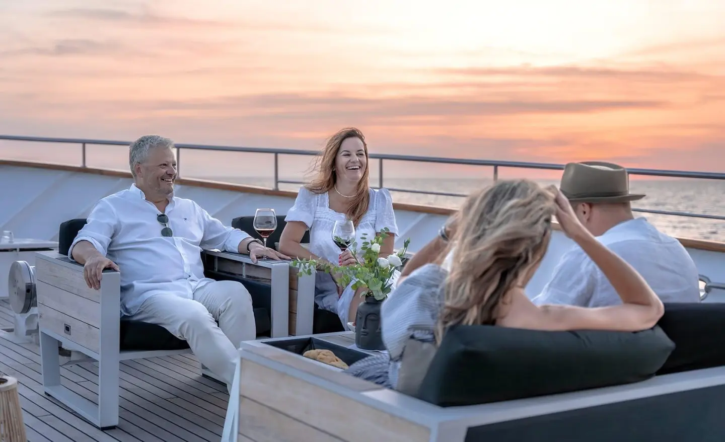 Karizma yacht bow deck with people relaxing at sunset on a terrace