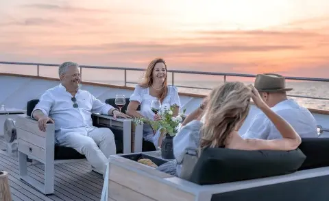Karizma yacht bow deck with people relaxing at sunset on a terrace