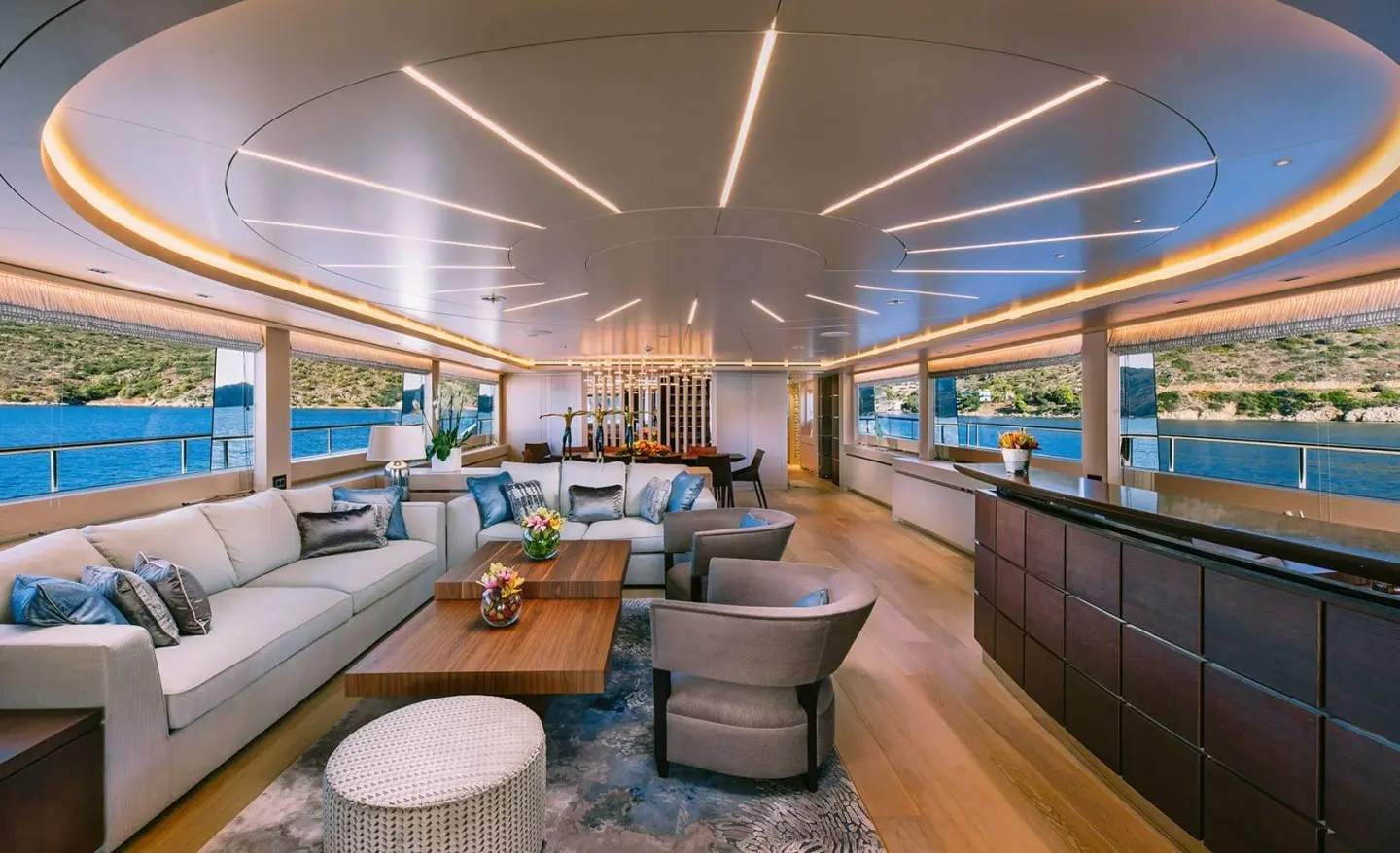 Luxurious yacht Xana interior cabin with seating, tables, and ambient lighting