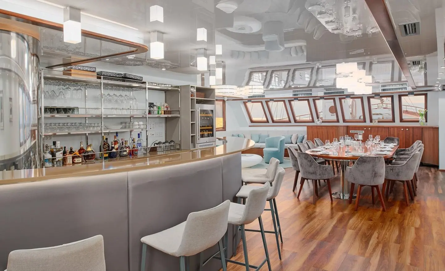 Luxurious yacht Corsario interior with seating, bar, and dining area at sunset